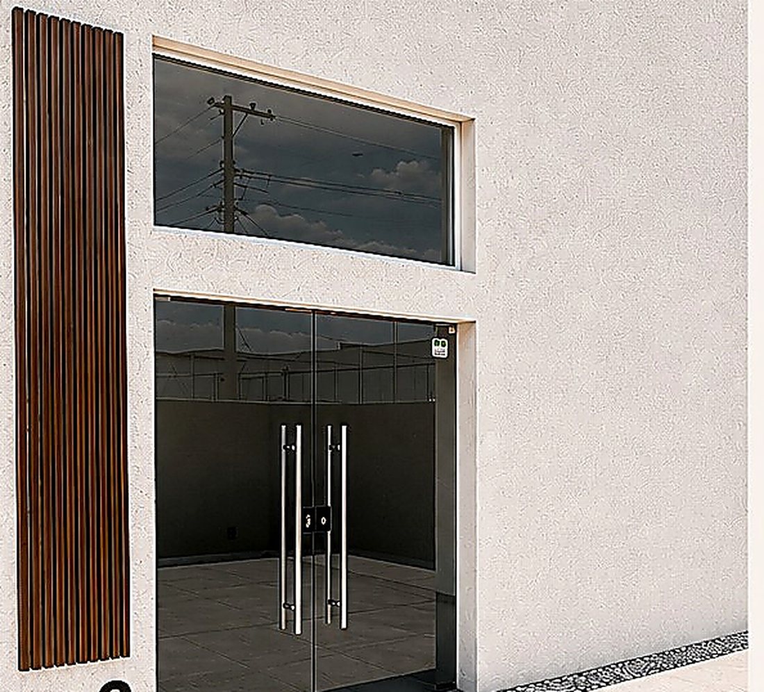 Acceso de un local comercial con cristal templado y celosía de madera